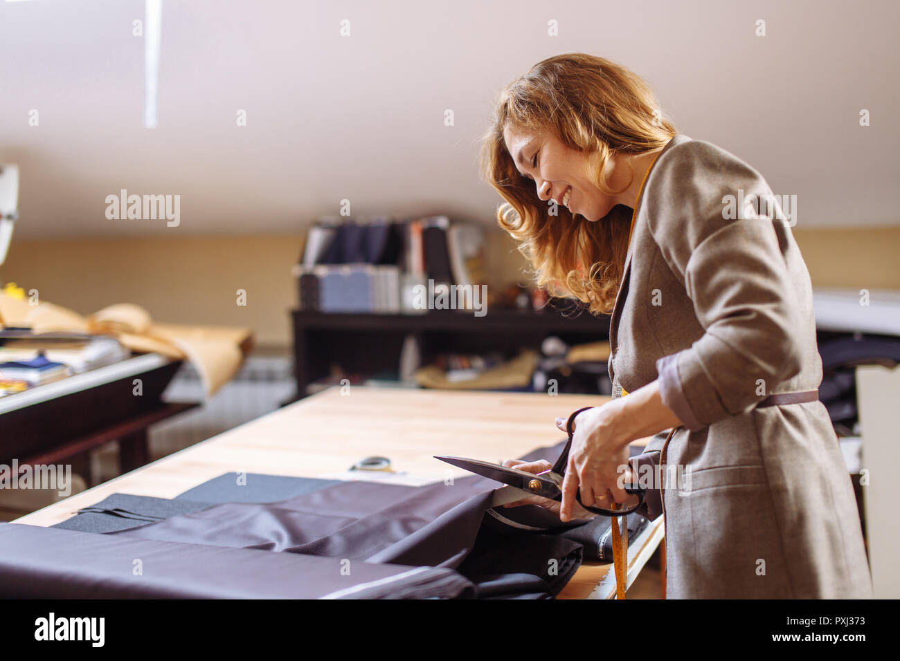Designer de mode féminine travaillant sur tissu habillent avec accessoires de couture sur la table Banque D'Images