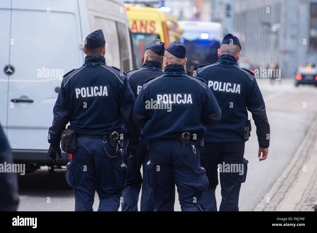 Groupe de policiers marchant dans la rue. Vêtu d'un uniforme bleu avec le signe de la police. Banque D'Images
