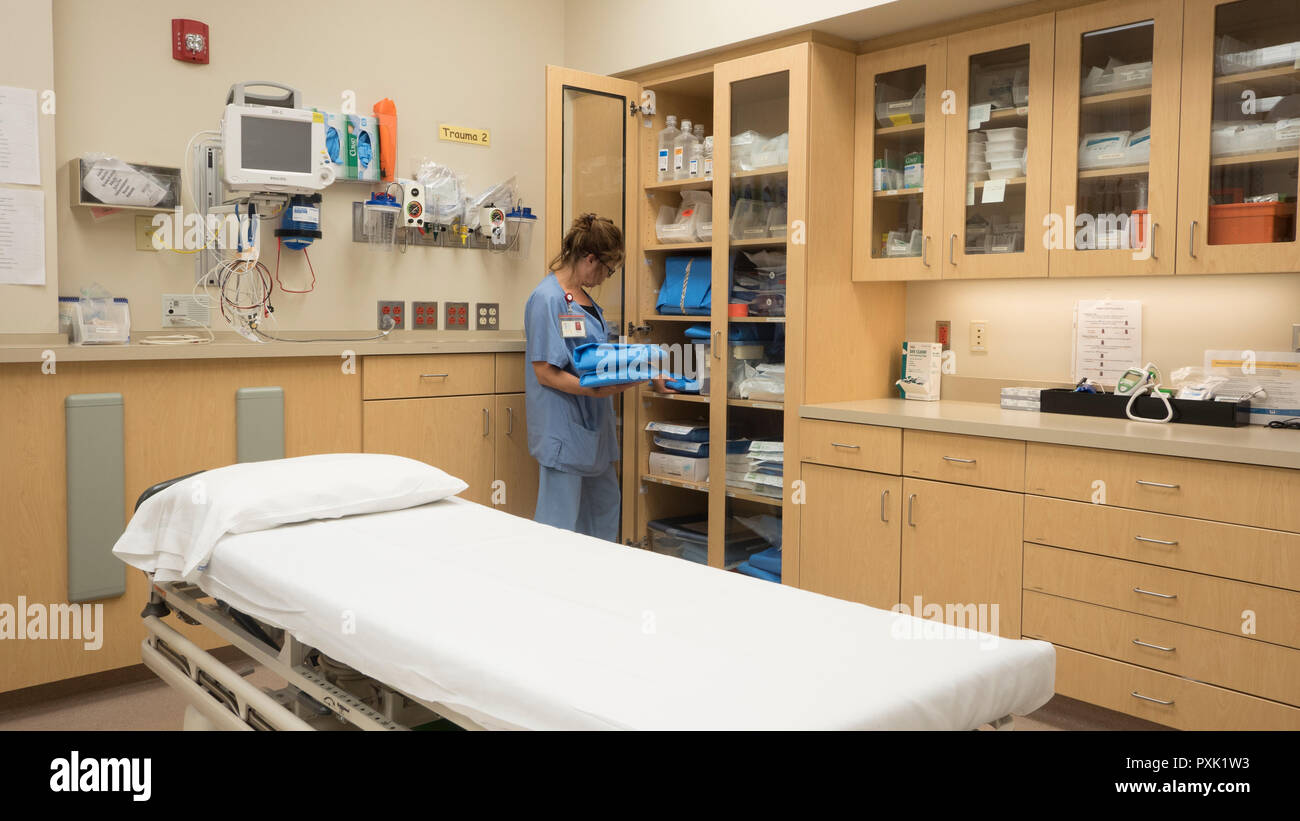 Une infirmière de salle d'urgence de l'hôpital en stock d'une armoire avec un traumatisme de fournitures. Banque D'Images
