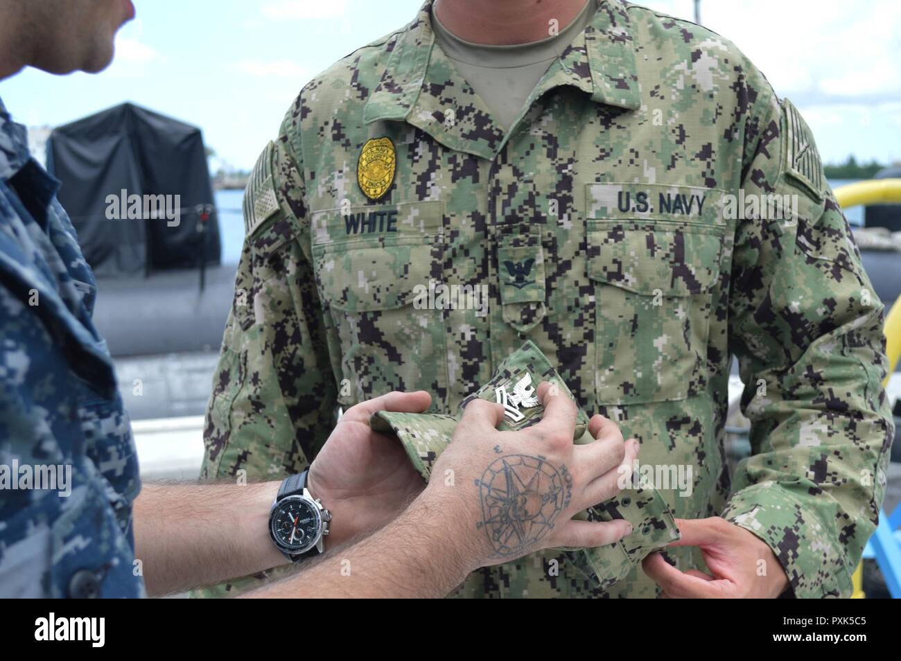 APRA HARBOUR, Guam (2 juin 2017) 4400 Machiniste (auxiliaire) de 2e classe Joseph Blanc, gauche, attribué à Los Angeles-classe d'attaque USS Chicago (SSN 721), les axes d'une 2e classe de maître de crow sur l'uniforme de la Marine en 8 points de Type III, couvrir de son frère, maître d'Armes 2e classe Jacob White, qui est affecté à la base navale de Guam les forces de sécurité. Les frères nouvellement promus, originaire de Gosport, Indiana, sont stationnés à Guam et rejoint la marine sept mois d'intervalle. Banque D'Images
