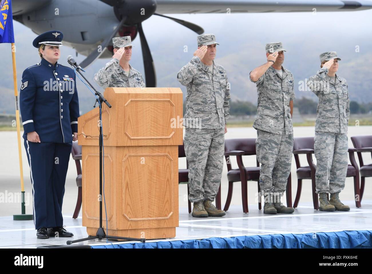 Le personnel de la Garde nationale américaine Sgt. À partir de la 562e Sarah Kumazawa Air National Guard Band de la côte ouest, chante l'hymne national tandis que le brigadier. L'Argile Gen, commandant de la garnison de la Garde nationale aérienne de la Californie, le Brigadier-général David M Bakos, sous-adjudant général de la Garde nationale aérienne de Californie, le colonel Y. Keith Ward, Commandant de la 146e Escadre de transport aérien, et le sergent-chef Chef. Cynthia Gregory avec la 146e Airlift Wing, saluer lors de la cérémonie de passation de commandement à la 146e Airlift Wing à Port Hueneme, Californie le 4 juin 2017. Banque D'Images