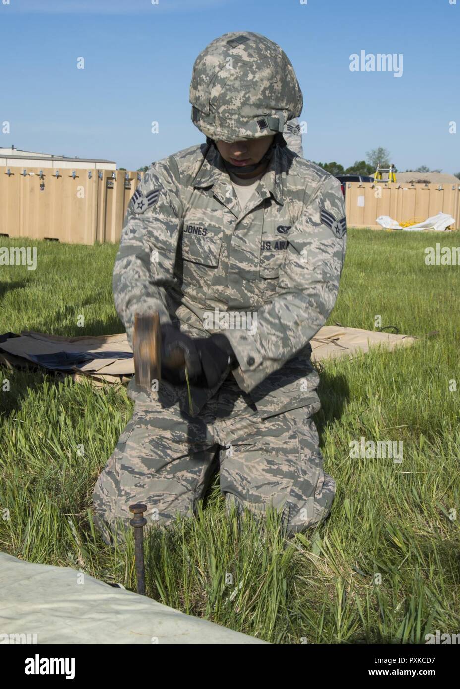 John Jones Senior Airman, 5e Escadron de génie civil, de marteaux apprenti structurels un pieu dans le sol à Minot Air Force Base, N.D., 1 juin 2017. Le 5ème construit ces deux tentes pendant la journée de formation expéditionnaire pour aider à préparer le déploiement potentiel d'aviateurs. Banque D'Images