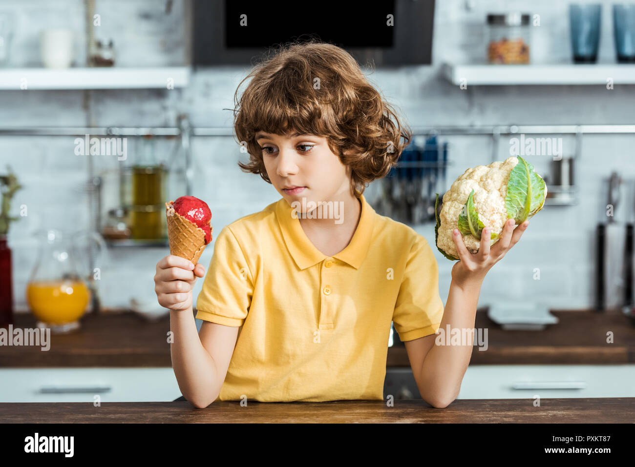 Boy holding délicieux de la crème glacée et le chou-fleur en bonne santé Banque D'Images