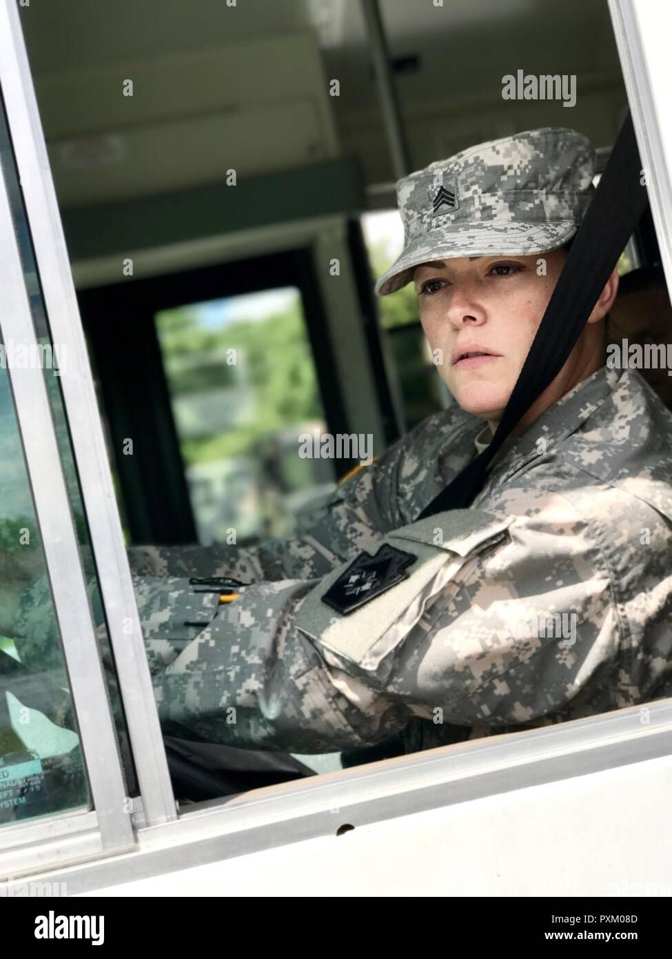 Le Sgt. Lisa Horan, un spécialiste de la purification de l'eau avec la 252ème Compagnie de quartier-maître, 728th Bataillon de soutien au maintien en puissance de combat, 213e groupe d'appui régional, New Jersey Army National Guard, vérifie son miroir avant de partir de l'aire de stationnement au cours de formation de conducteur de bus à Fort Indiantown Gap le 9 juin 2017. Banque D'Images