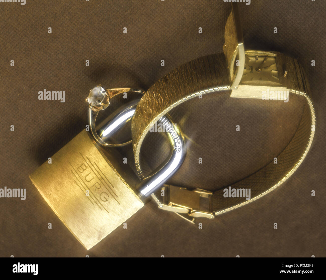 Uhr und Brillantring sind mit einem Vorhängeschloss gesichert Banque D'Images