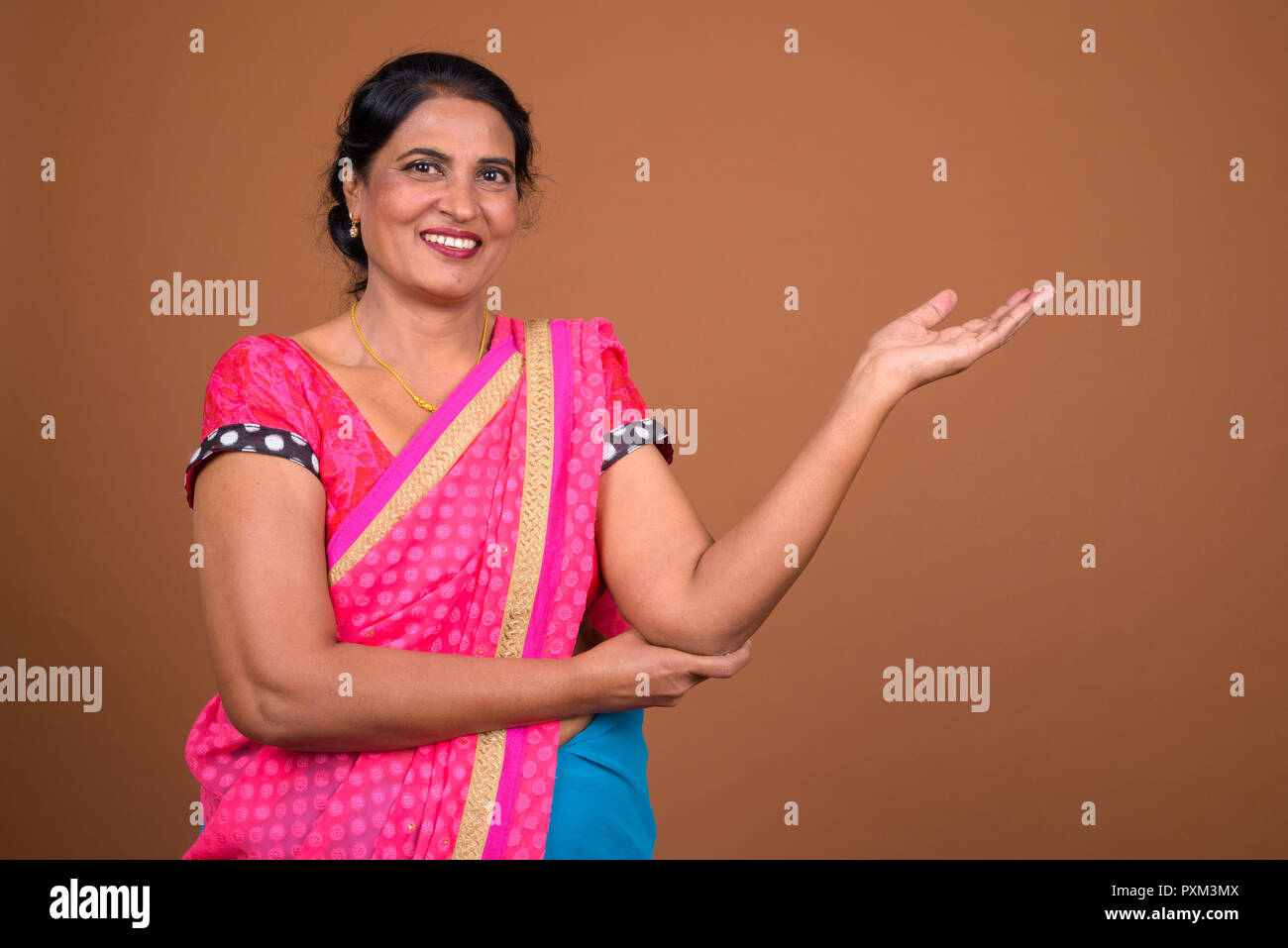 Heureux femme indienne portant des vêtements traditionnels et montrant copy space Banque D'Images