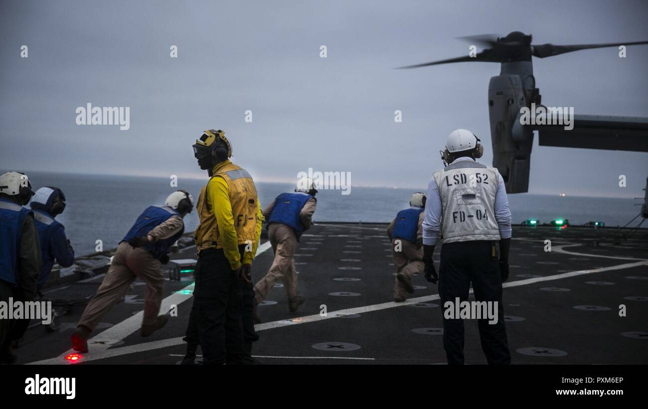 Océan Pacifique - Marines au combat, cargo, 15e Marine Expeditionary Unit et les marins affectés au service du pont à bord du USS Pearl Harbor (LSD 52) exécuter pour supprimer les chaînes de sécurité d'un MV-22B Balbuzard pêcheur sur le pont d'envol du navire au cours de l'exercice de certification, le 5 juin 2017. L'interopérabilité est une compétence essentielle de l'équipe bleu-vert doit avoir des opérations pendant le déploiement. CERTEX est la dernière d'une série d'exercices de formation, qui certifie la MEU-ARG équipe capable d'un déploiement à l'appui de la flotte et les commandants de combat dans toute la gamme des opérations militaires. Banque D'Images