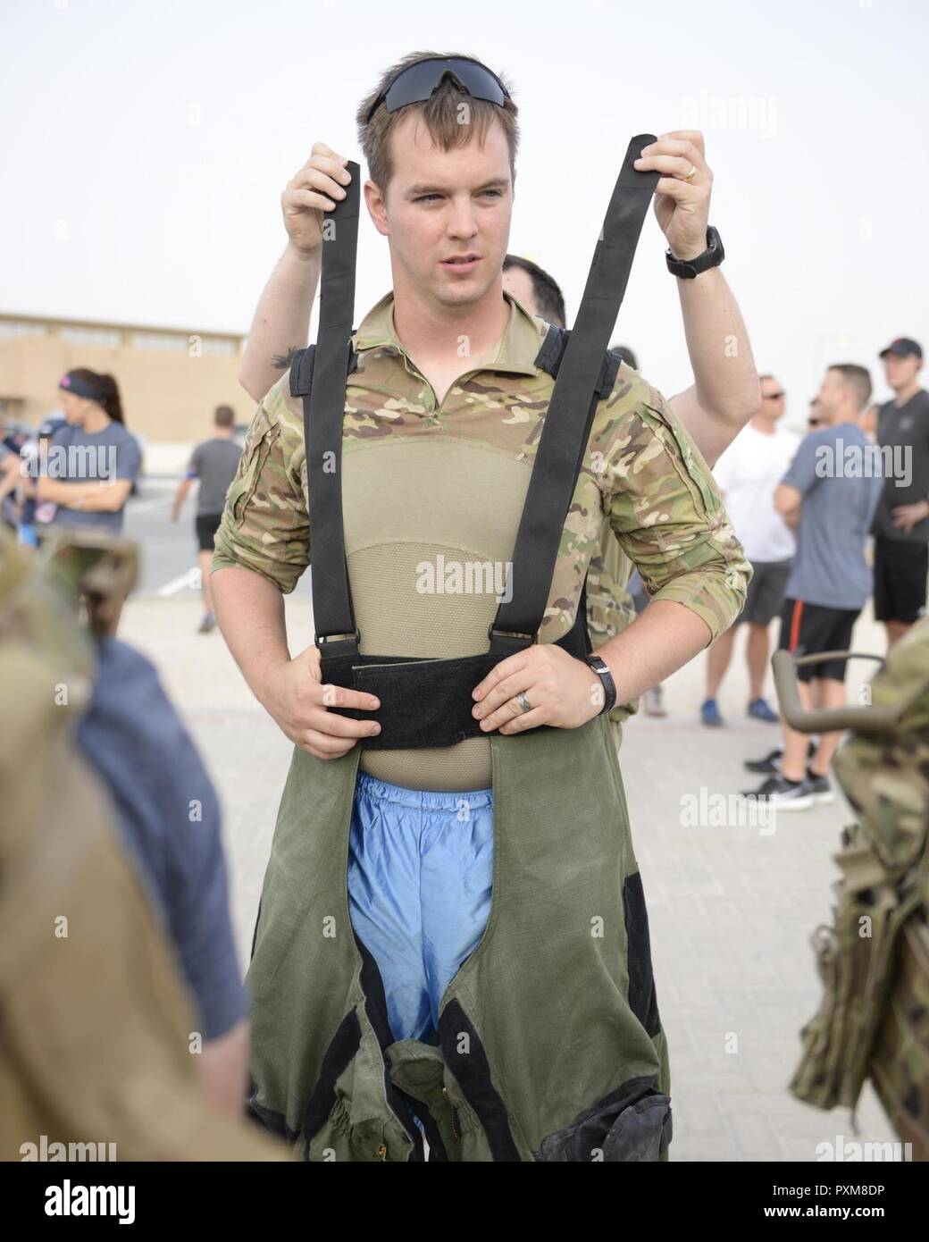 Le sergent de l'US Air Force. Points Brent, explosifs, technicien affecté à la 379e Escadron de génie civil, reçoit l'aide d'enfiler la combinaison antibombe il va porter à l'assemblée annuelle de l'EOD 5K Run Memorial à Al Udeid Air Base, Qatar, le 3 juin 2017. Des points joints d'autres membres de NEM, ainsi que les service membres de l'ensemble de la base de participer à l'EOD 5K Run commémoratif à la mémoire de l'EOD hommes et femmes tués en action au cours d'opérations de combat. Banque D'Images