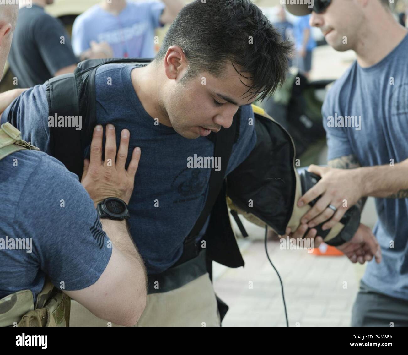 Les cadres supérieurs de l'US Air Force Airman Cory McLellan, technicien des explosifs et affecté à la 379e Escadron de génie civil, reçoit l'aide de retirer la combinaison antibombe il portait lors de l'EOD annuelle 5K Run Memorial à Al Udeid Air Base, Qatar, le 3 juin 2017. McLellan a rejoint les membres en service de l'ensemble de la base qui se sont réunis pour prendre part à l'EOD 5K Run commémoratif à la mémoire de l'EOD hommes et femmes tués en action au cours d'opérations de combat. Banque D'Images