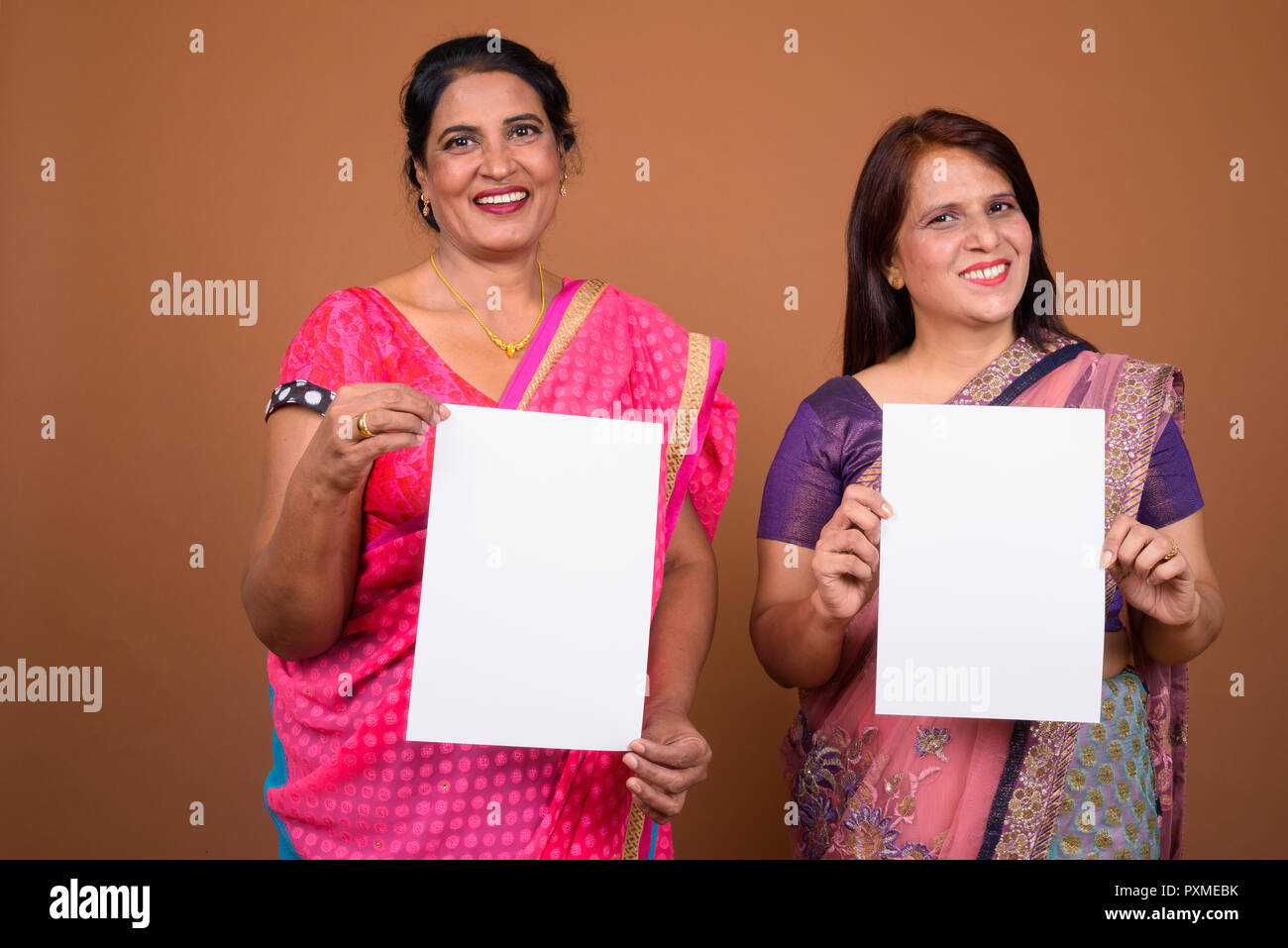Deux Indian woman holding empty white paper with copy space Banque D'Images