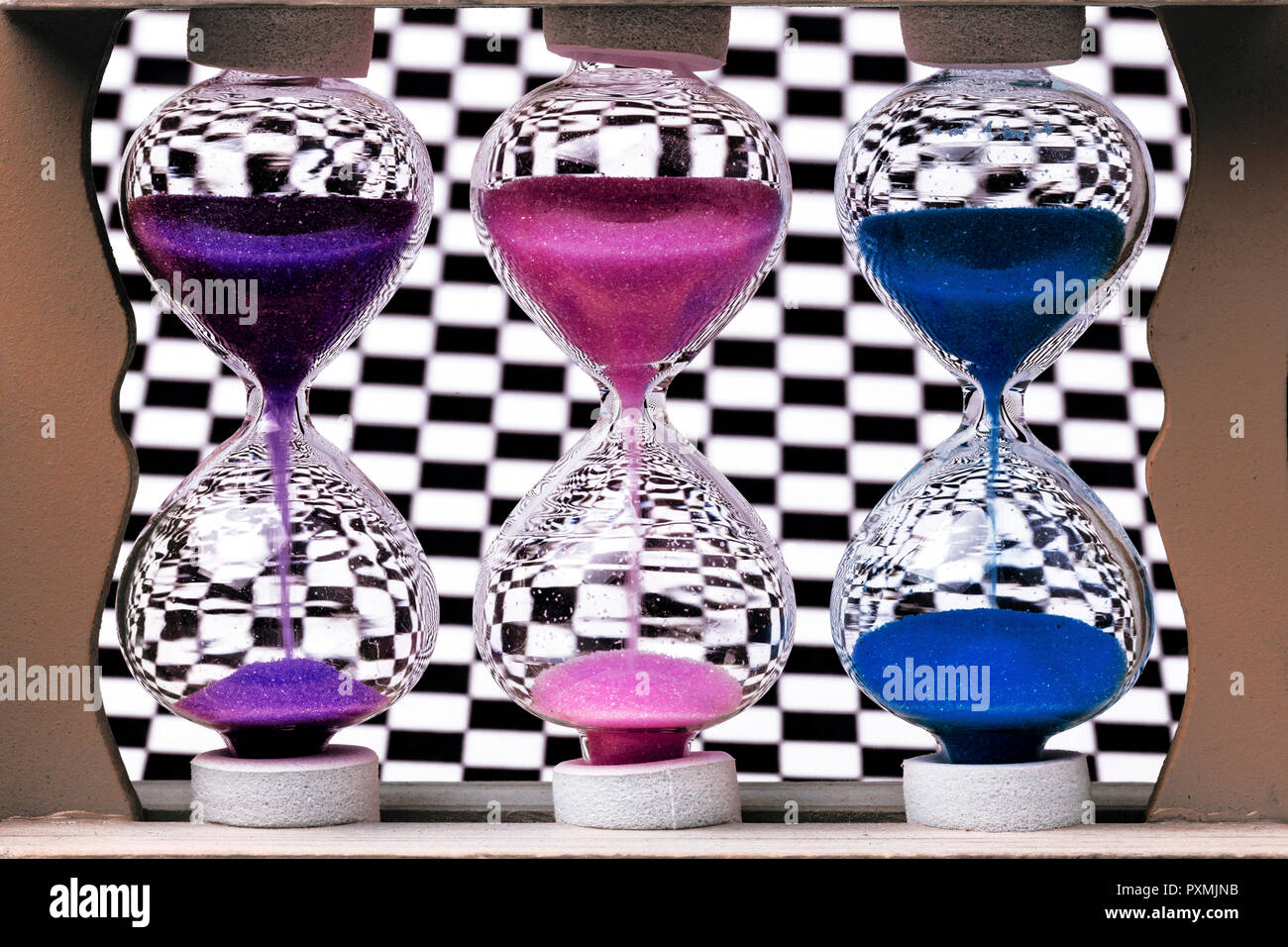 Hourglass colorés sur le fond de la paroi d'échecs Banque D'Images