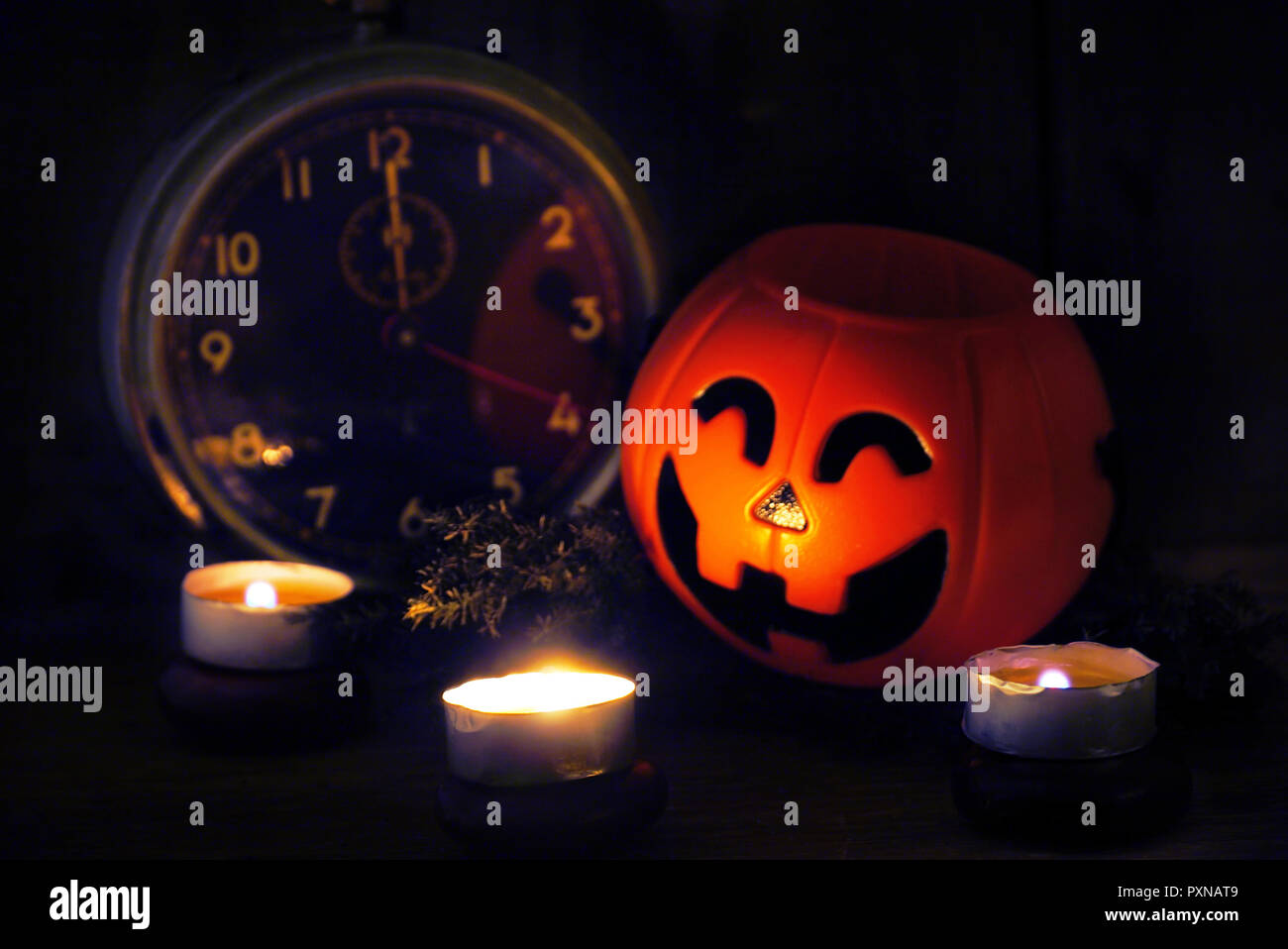 Sur loght bougie citrouille sourire et vieux réveil à minuit le jour de l'halloween Banque D'Images
