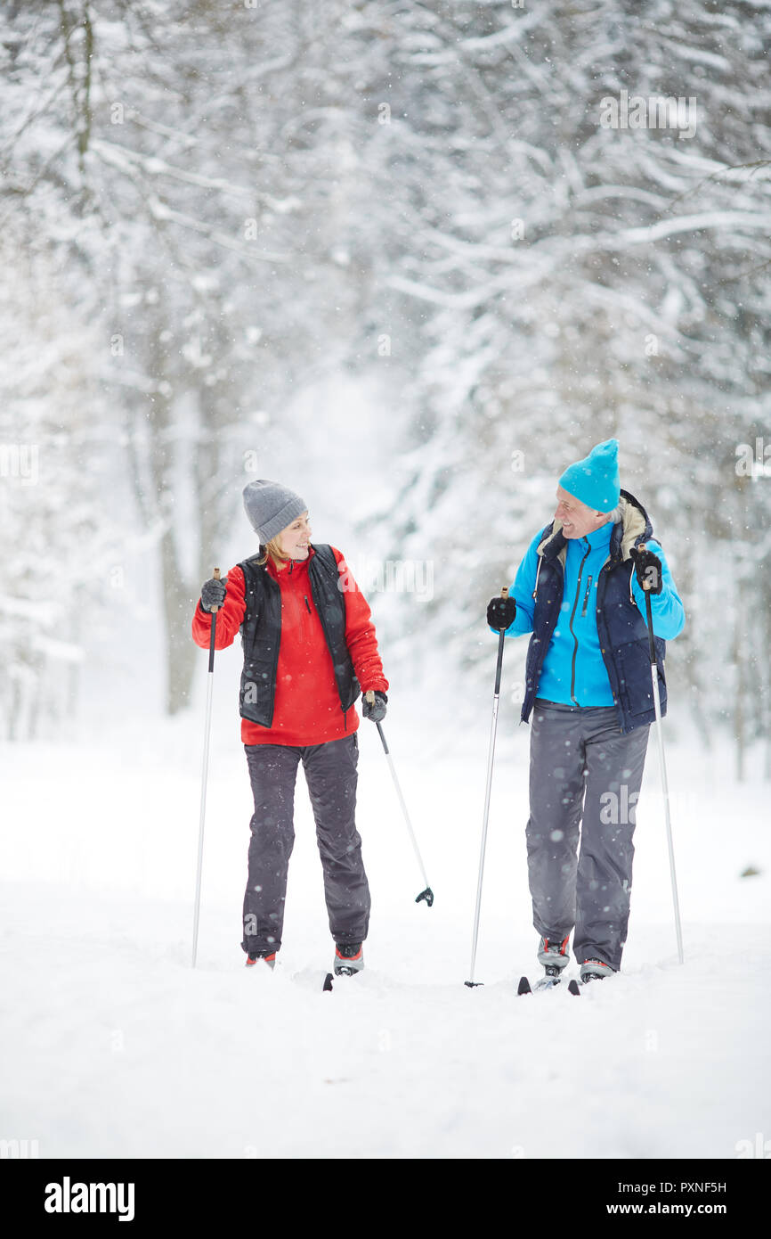 Les époux en maturité sportive activewear le ski en neige à loisir sur journée d'hiver Banque D'Images