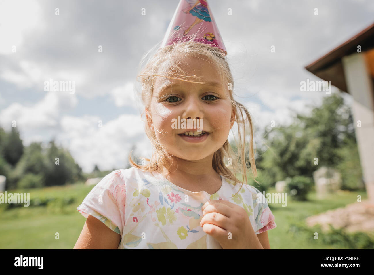 Portrait of smiling little girl wearing paper cone Banque D'Images