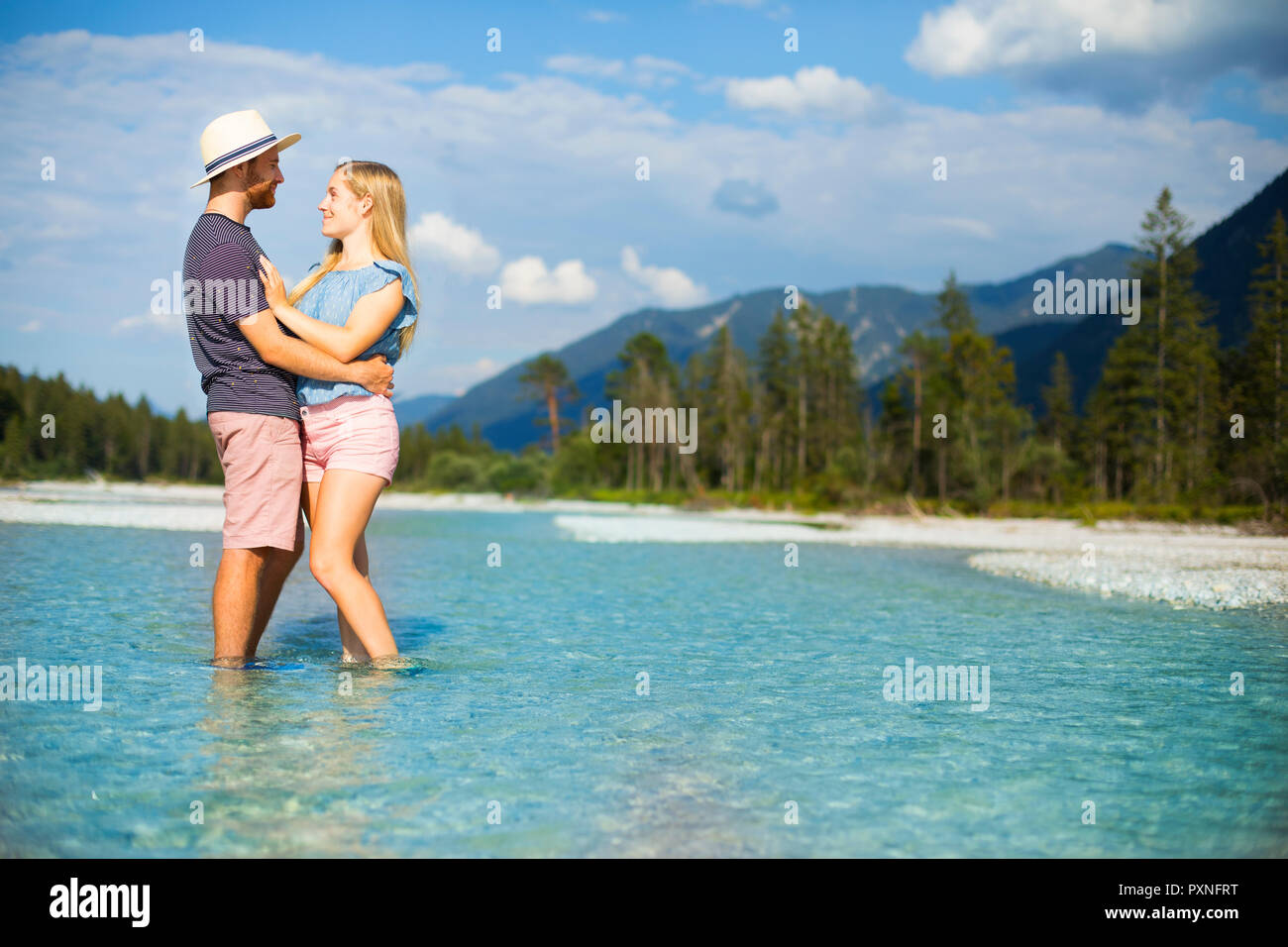 Jeune couple debout dans l'eau, Faire place au Banque D'Images