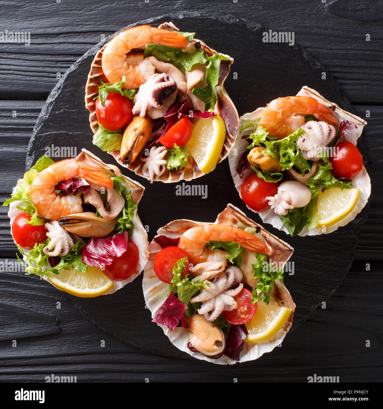 Cocktail De Fruits De Mer Magnifique Salade De Crevettes Poulpe Bebe Moules Calmars Et Les Petoncles Avec Legumes En Coquilles De Mer Gros Plan Sur Un Tableau Noir Top Vi Photo Stock