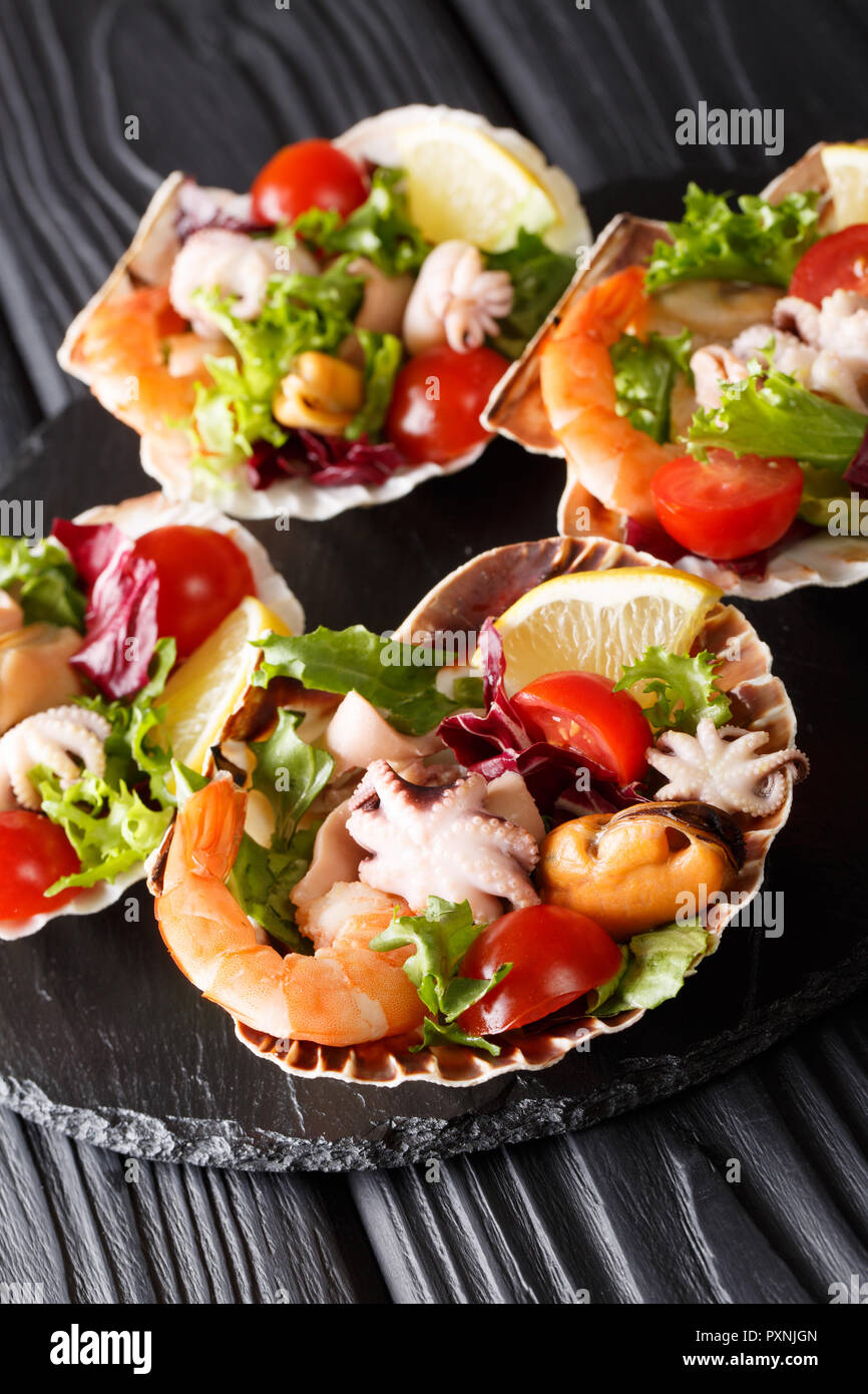 Salade De Fruits De Mer Gastronomique De Crevettes Poulpe Bebe Moules Calmars Et De Petoncles En Coquilles De Mer Gros Plan Sur La Table Verticale Photo Stock Alamy