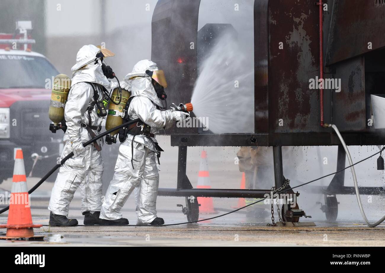 Le s.. Logan Knutson et Navigant de première classe Hannah Reichert, 81e Division Infrastructure pompiers, utiliser un tuyau pour éteindre un pompier les aides à la formation au cours de l'exercice de tir réel sur la piste le 7 juin 2017, sur la base aérienne de Keesler, mademoiselle l'incendie, le ministère de Keesler Gulfport CRTC Fire Department et le service d'incendie de Stennis Space Center sont tous nécessaires à la pratique service de Sauvetage et lutte contre les incendies pour répondre à une exigence de formation semi-annuel. Banque D'Images