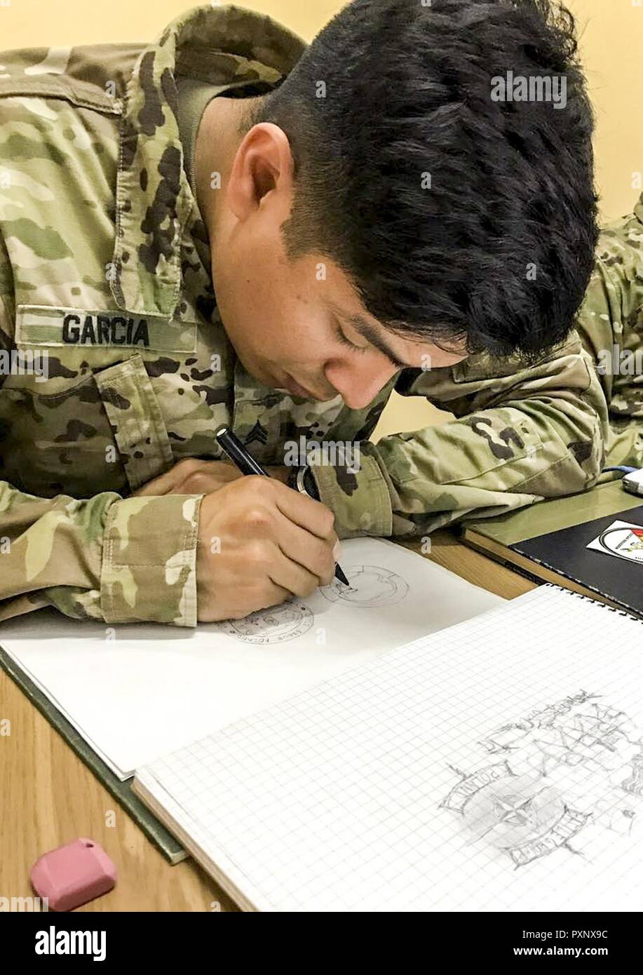 Pologne Groupe bataille soldat américain, le Sgt. Luis Garcia Velez attire dans son carnet de croquis dans Bemowo Piskie Zone formation le 9 juin. Garcia est un véhicule Stryker avec le commandant des troupes de l'Aigle et est stationnée en Pologne ainsi que d'autres groupe de combat américains, britanniques et soldats roumains à l'appui de l'OTAN vers l'amélioration de la présence. Banque D'Images