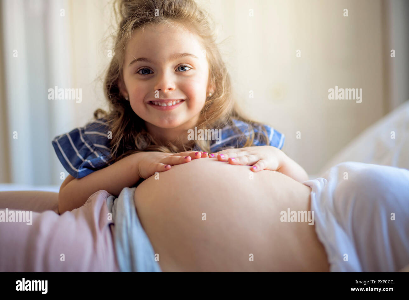 Femme enceinte avec sa fille sur l'ensemble de chambre à coucher Banque D'Images