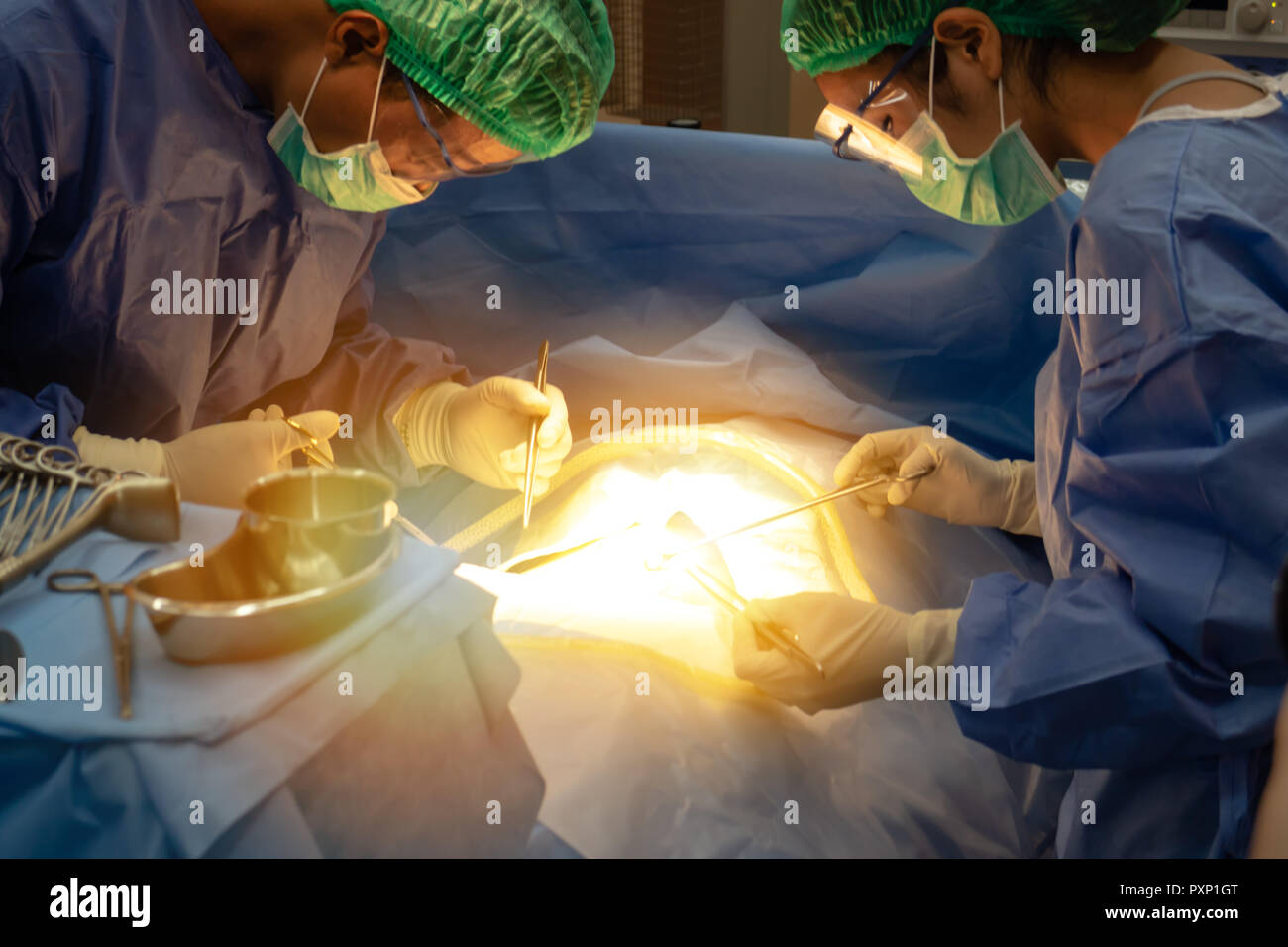 La technologie médicale à l'hôpital intelligent concept, médecin dans l'équipe de chirurgiens field holding medical instruments de chirurgie le patient en salle d'opération Banque D'Images