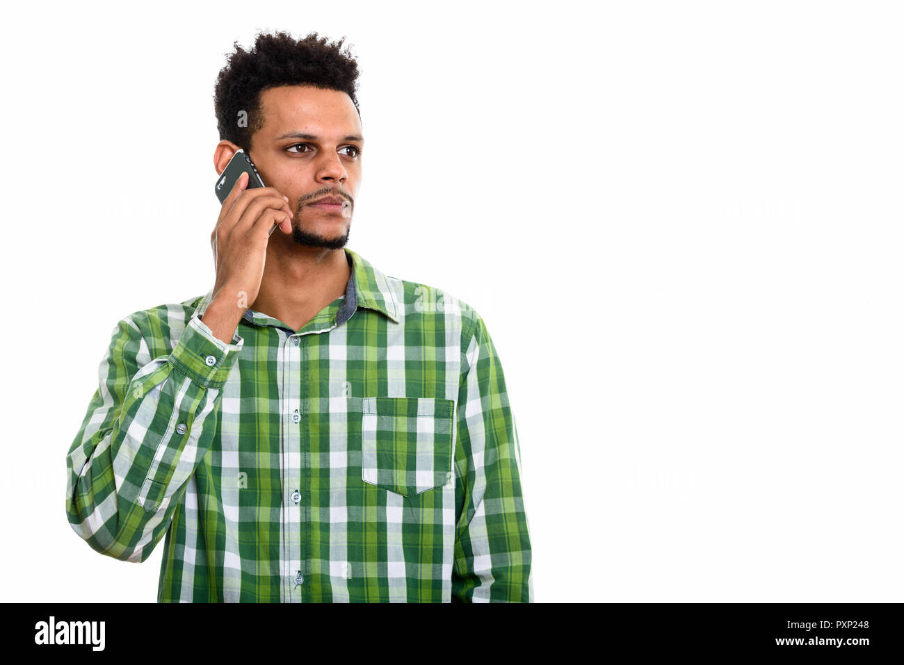 Studio shot of young African man talking on mobile phone alors que t Banque D'Images