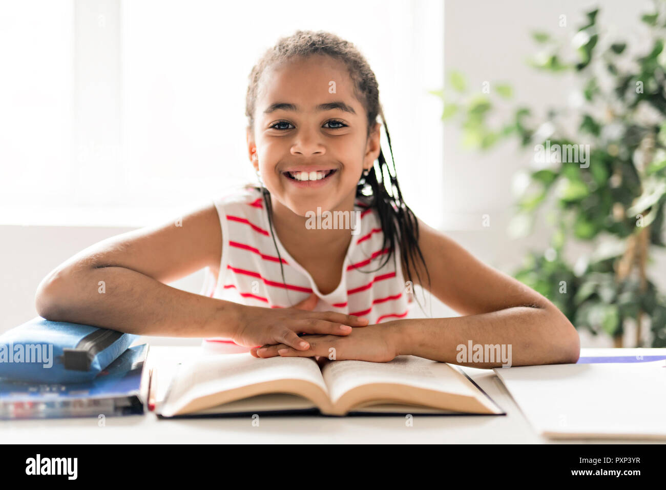 Un mignon black girl doing homework at home Banque D'Images