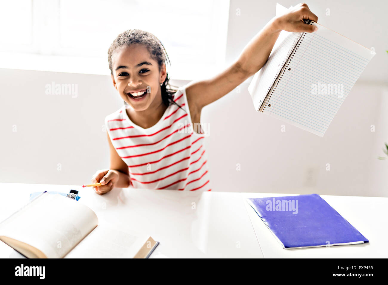 Un mignon black girl doing homework at home Banque D'Images