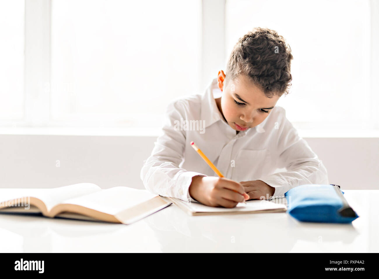 Un mignon petit noir à faire des devoirs à la maison Banque D'Images