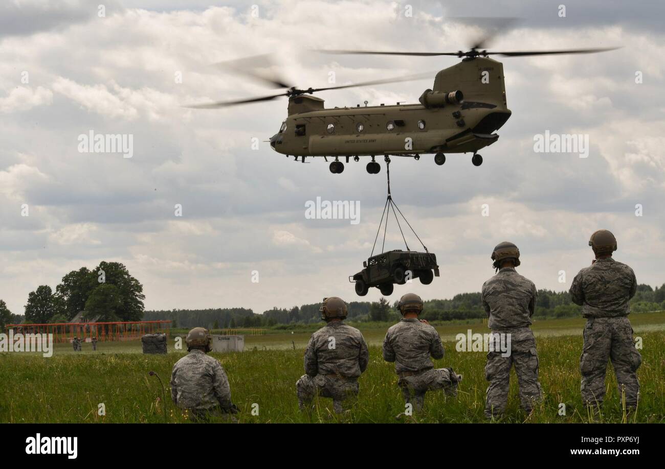 Les aviateurs de l'US Air Force de réserve affecté à la 435ème groupe de réponse regarder un HUMVEE suspendu d'un CH-47 Chinook de l'armée américaine pour la 435ème de l'élingue du GRC Opération de chargement pendant l'exercice 17 à Lielvarde grève Sabre Air Base, Lettonie, 10 juin 2017. Le CRG 435ème arrimé les aviateurs à l'HUMVEE et Chinook ont regardé pour s'assurer qu'il avait été monté correctement. Grève sabre 17 met en évidence la souplesse inhérente de forces terrestres et aériennes pour répondre rapidement aux crises pour permettre la présence de droite là où c'est nécessaire, quand c'est nécessaire. Banque D'Images