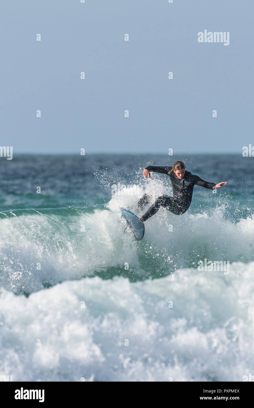 UK surf - un surfer une vague à la plage de Fistral à Newquay en Cornouailles. Banque D'Images
