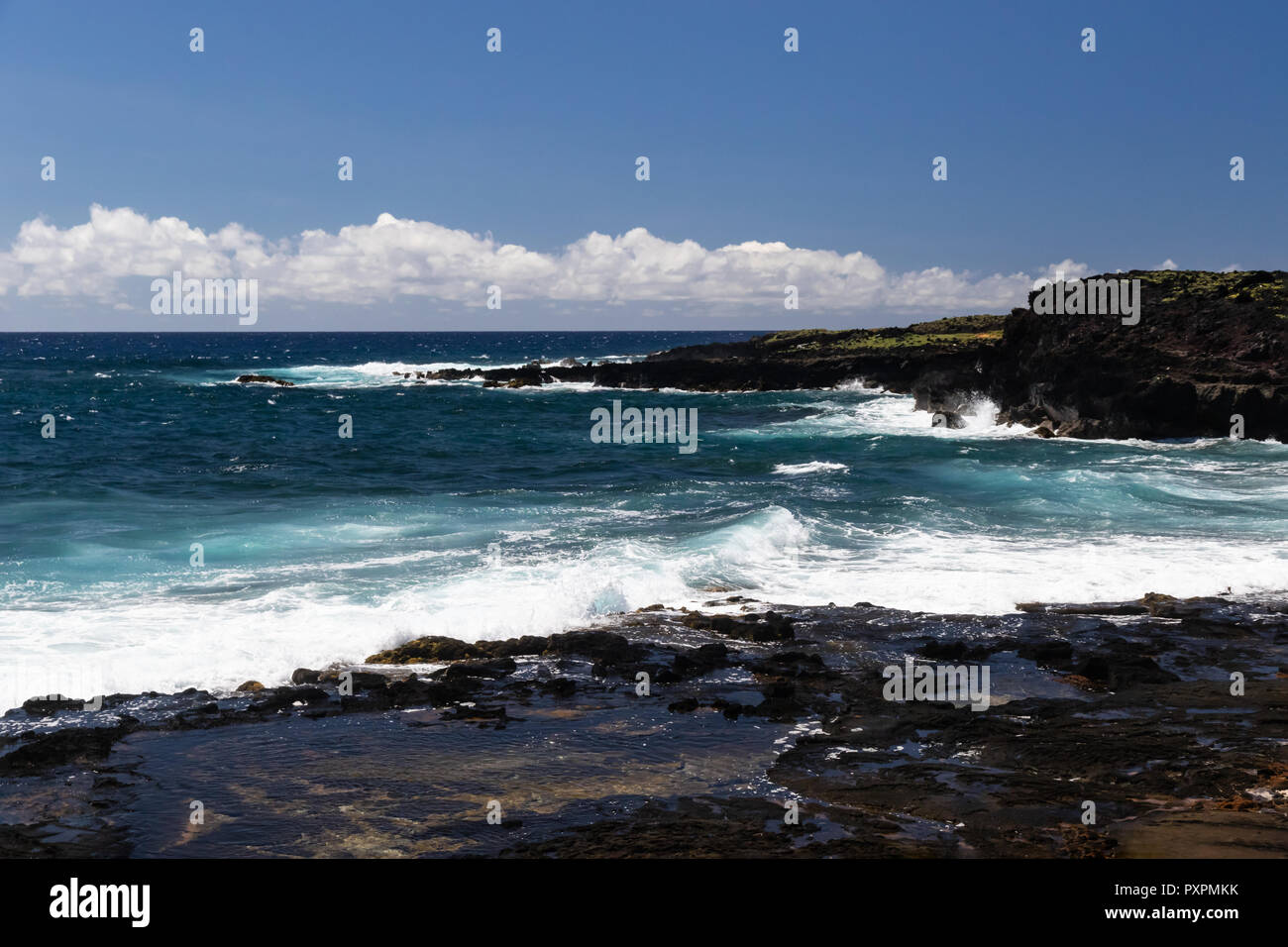 Rivage sur Grande Île d'Hawaï près de South Point. Bleu profond de l'océan Pacifique, les vagues se brisant sur le littoral. Petite cuvette en premier plan. Banque D'Images