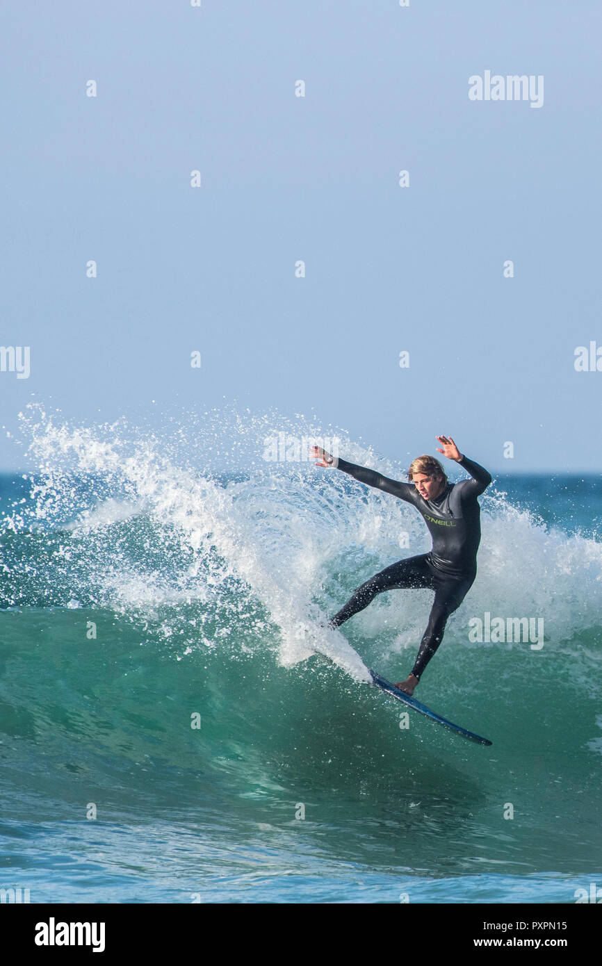 UK surf - un surfer une vague à la plage de Fistral à Newquay en Cornouailles. Banque D'Images