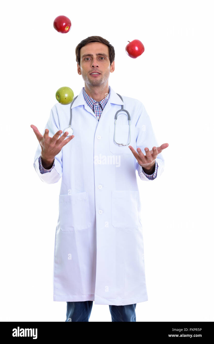 Studio shot of young handsome man doctor standing tout en jonglant avec Banque D'Images