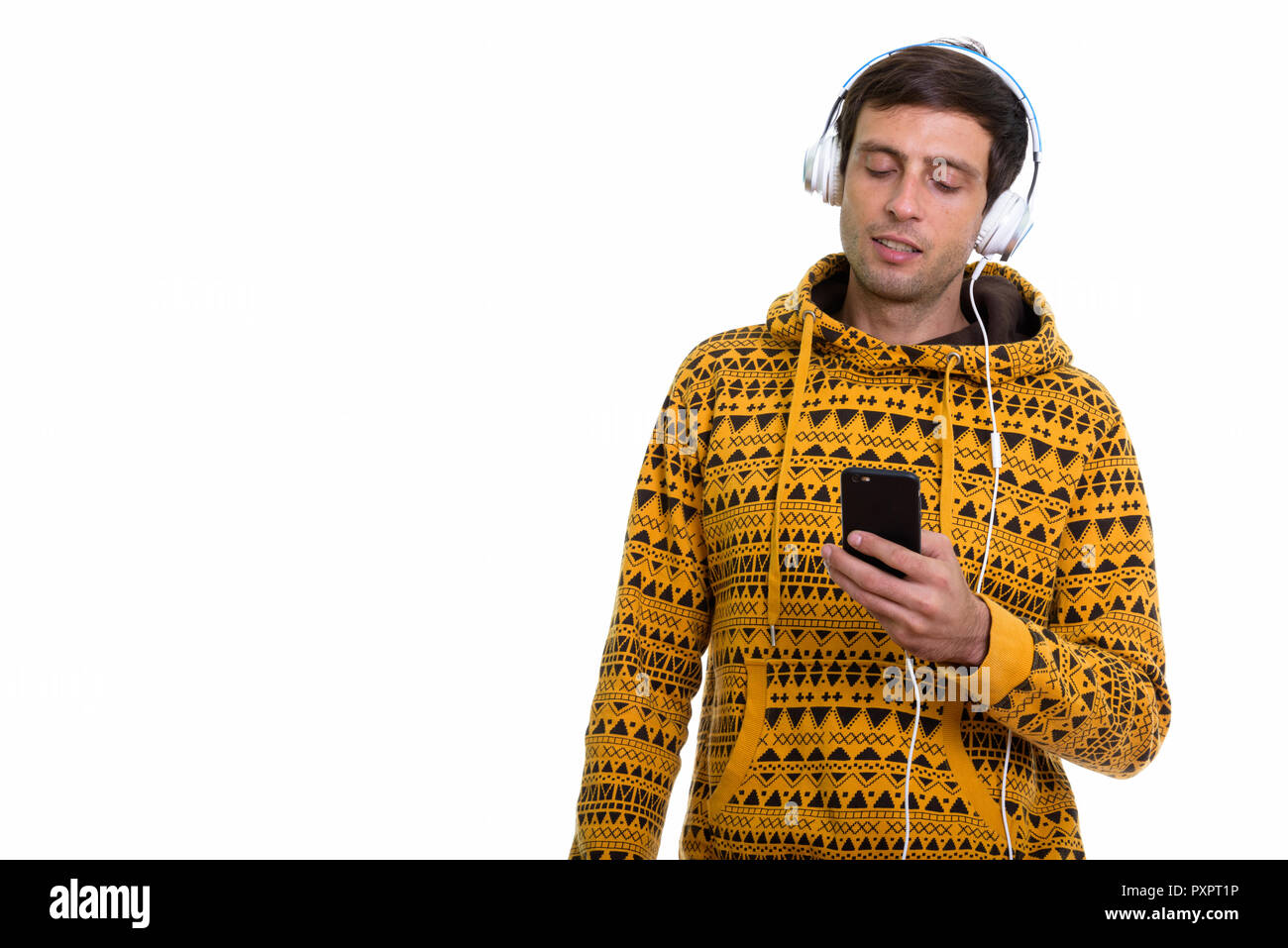 Portrait de jeune homme séduisant à l'écoute de la musique tout en utilisant Banque D'Images