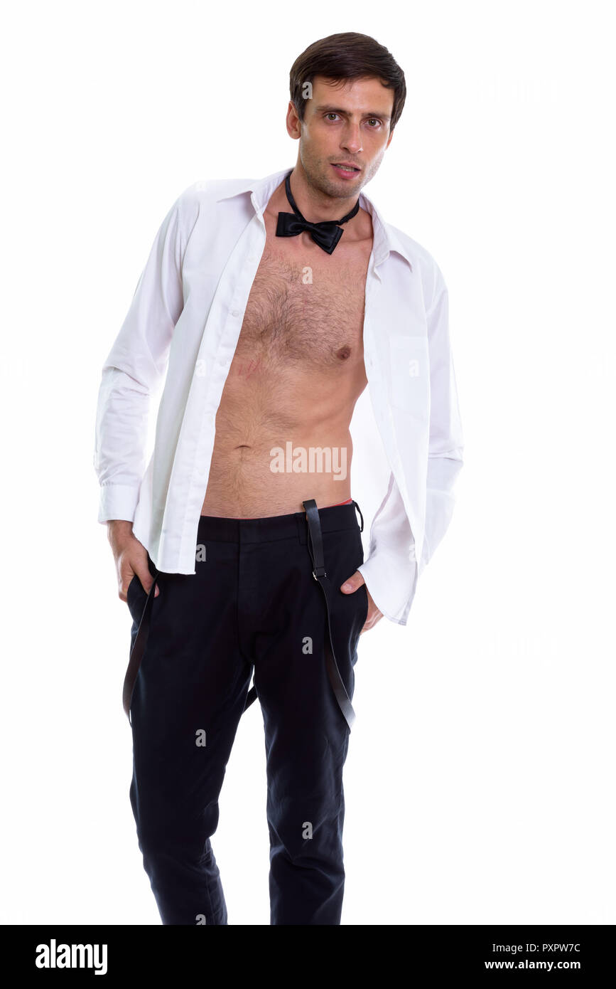 Studio shot of young handsome man standing with open shirt tandis que Banque D'Images