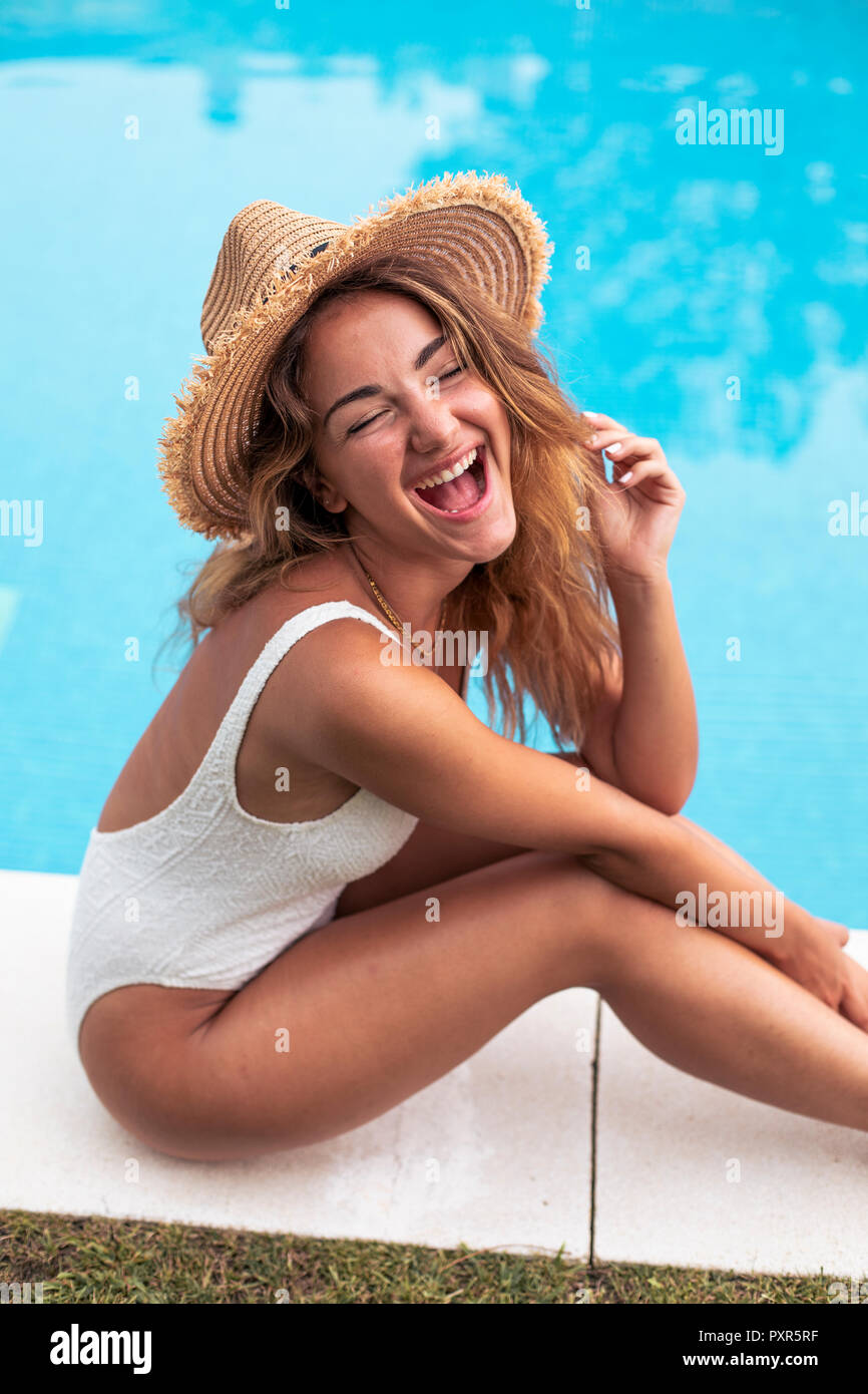 Young Girl smiling with straw hat maillot et assis à un Banque D'Images