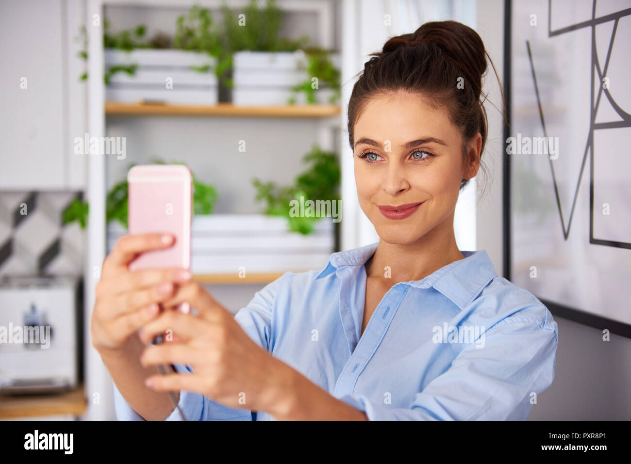Jeune femme à la cuisine, prendre des selfies Banque D'Images