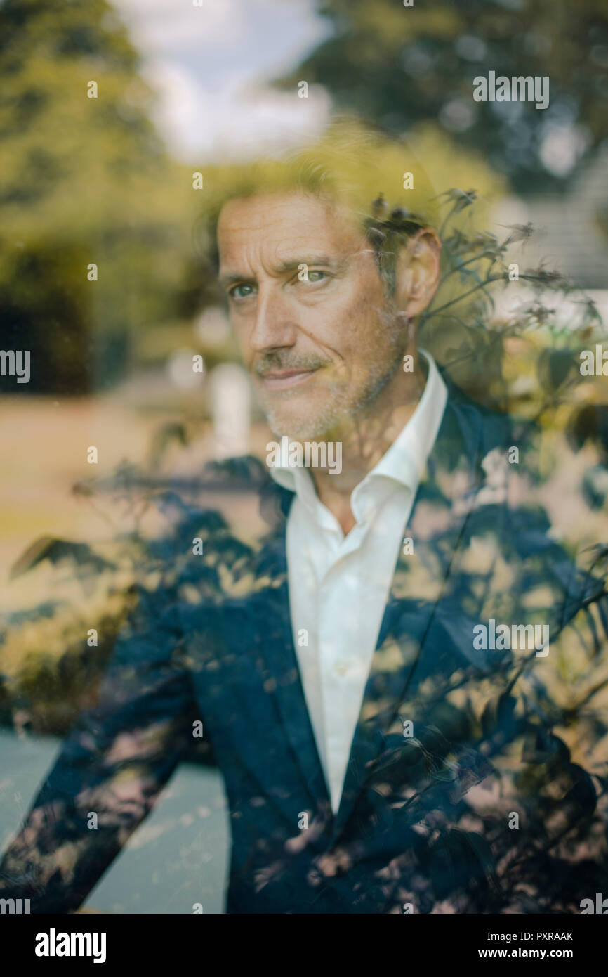 Le portrait d'un businessman standing at window Banque D'Images
