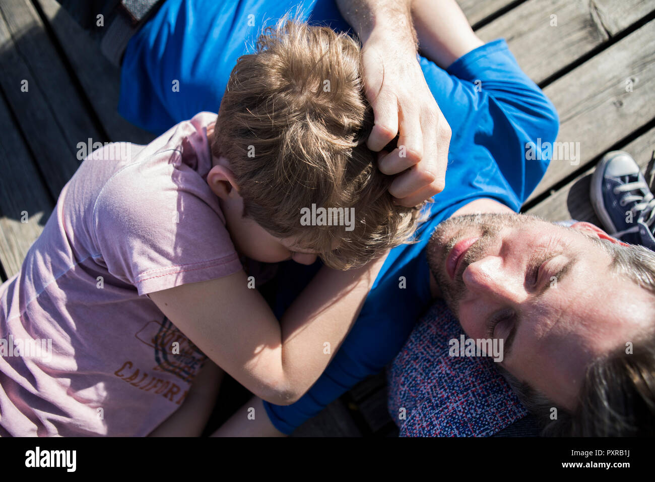 Famille et fils gisant sur une jetée Banque D'Images