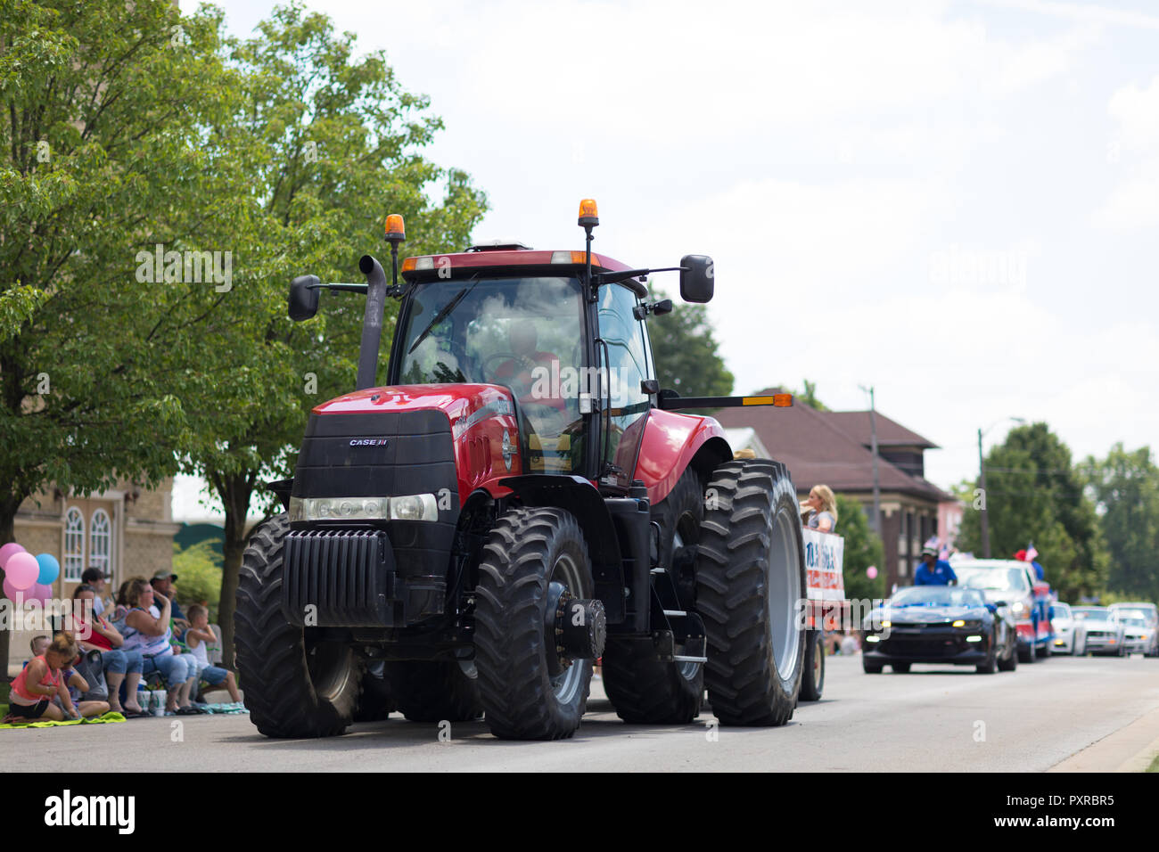 Kokomo, Indiana, USA - 30 juin 2018 : Haynes Apperson Parade, un grand tracteur Case IH Magnum rouge tirant une charrette en descendant la route Banque D'Images