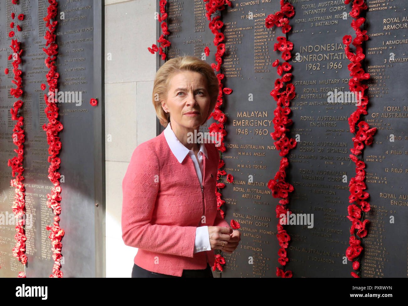 Canberra, Australie. 24 Oct, 2018. Le ministre fédéral de la défense, Ursula von der Leyen (CDU) est debout devant un mur avec les noms de tous les soldats australiens tombés au cours de la Seconde Guerre mondiale et après la pose de la couronne dans le Mémorial Australien de la guerre. Les coquelicots en plastique insérée rendre hommage aux morts. Von der Leyen est en Australie pour une visite de deux jours. Credit : Subel Bhandari/dpa/Alamy Live News Banque D'Images