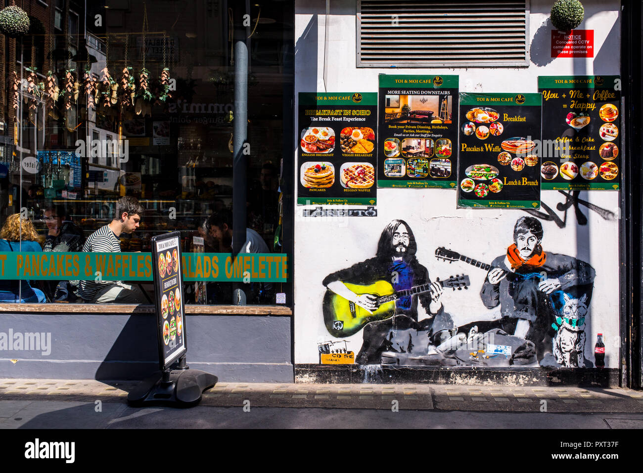 Nouvelle murale graffiti street art de Loretto : les Beatles Lennon et McCartney qui joue de la guitare comme sans-abri musiciens amuseurs de rue Banque D'Images