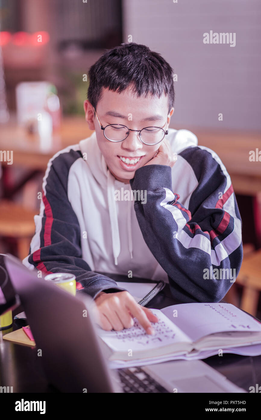 Genre garçon asiatique tâche de lecture dans un livre Banque D'Images