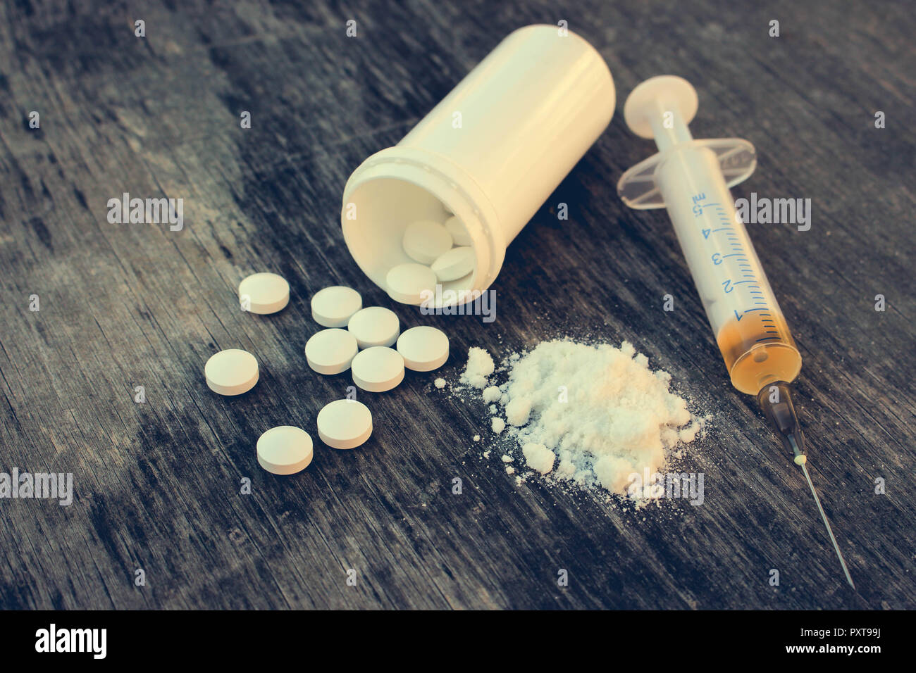 La toxicomanie sur le vieux fond de bois. Comprimé blanc, la seringue et l'héroïne. Banque D'Images