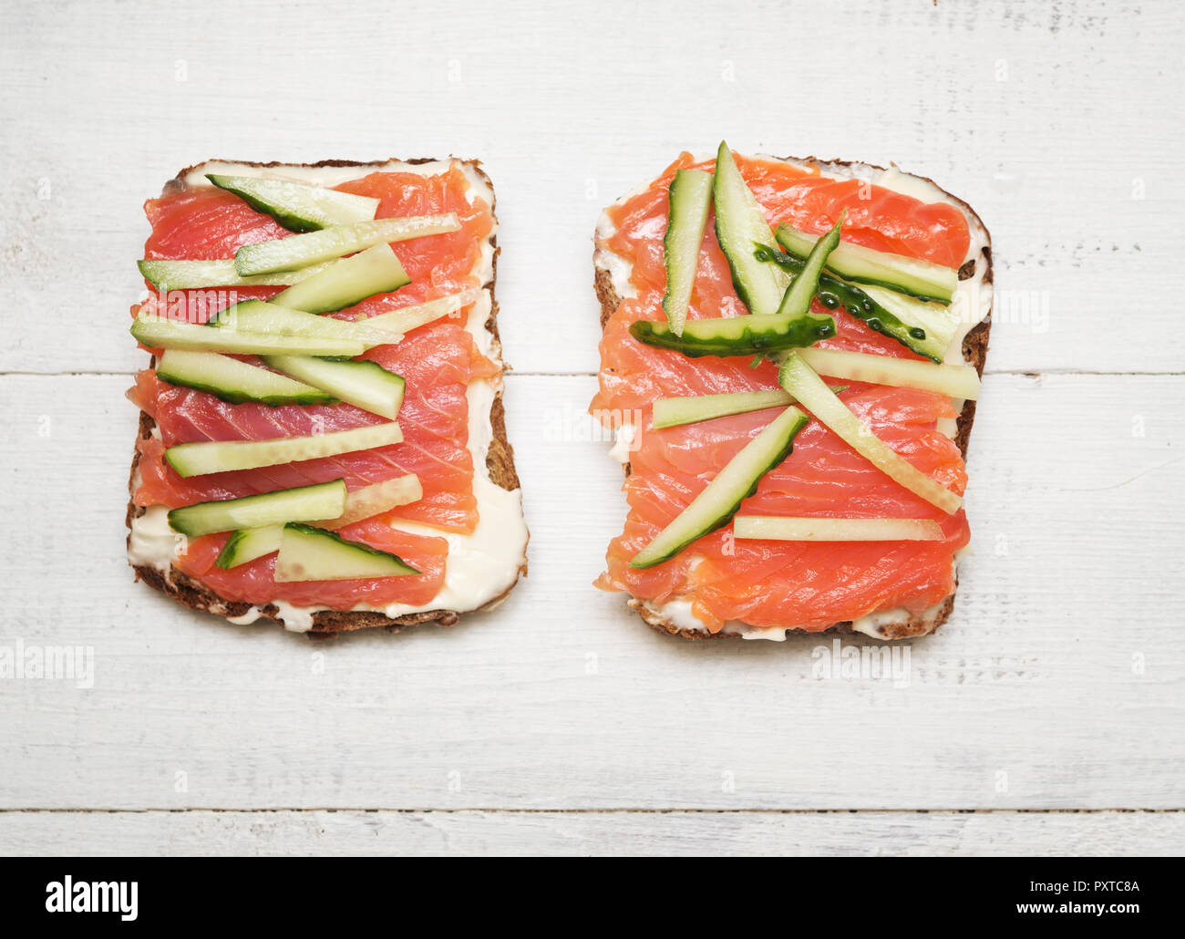 Deux sandwiches avec du poisson rouge et le concombre sur fond de bois Banque D'Images