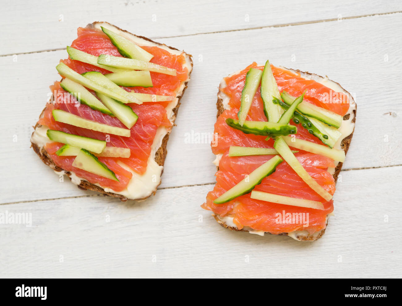 Deux sandwiches avec du poisson rouge et le concombre sur fond de bois Banque D'Images