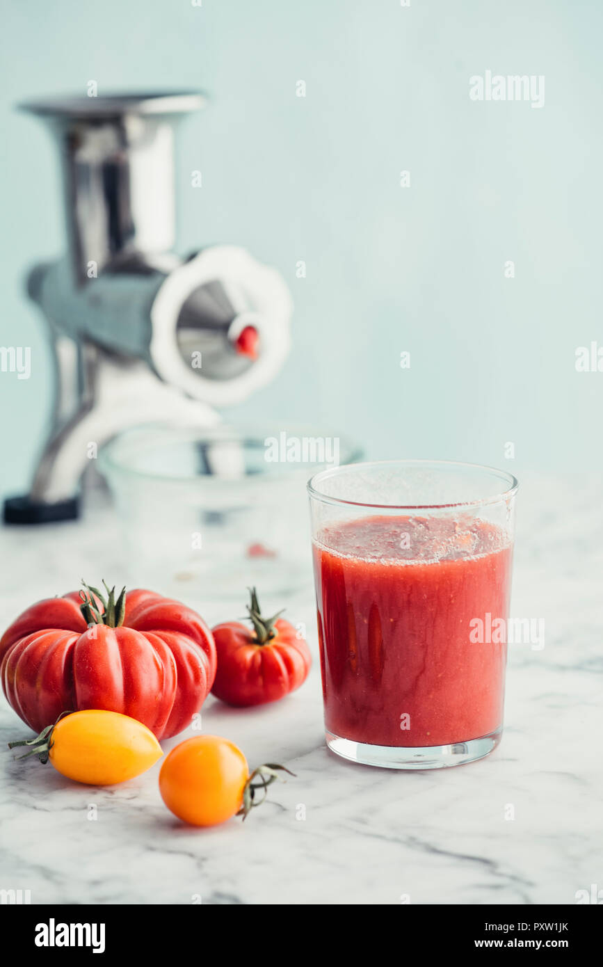 Jus de tomate fraîche dans un verre, comme centrifugeuse hachoir dans  l'arrière-plan Photo Stock - Alamy