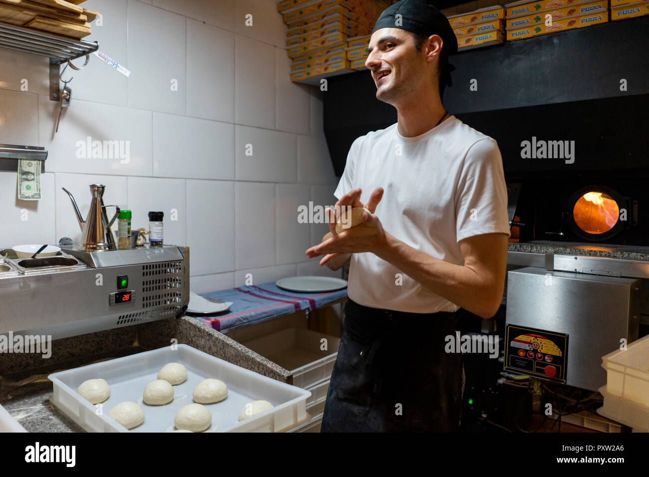 Pizza pâte à modeler baker Smiling in kitchen Banque D'Images
