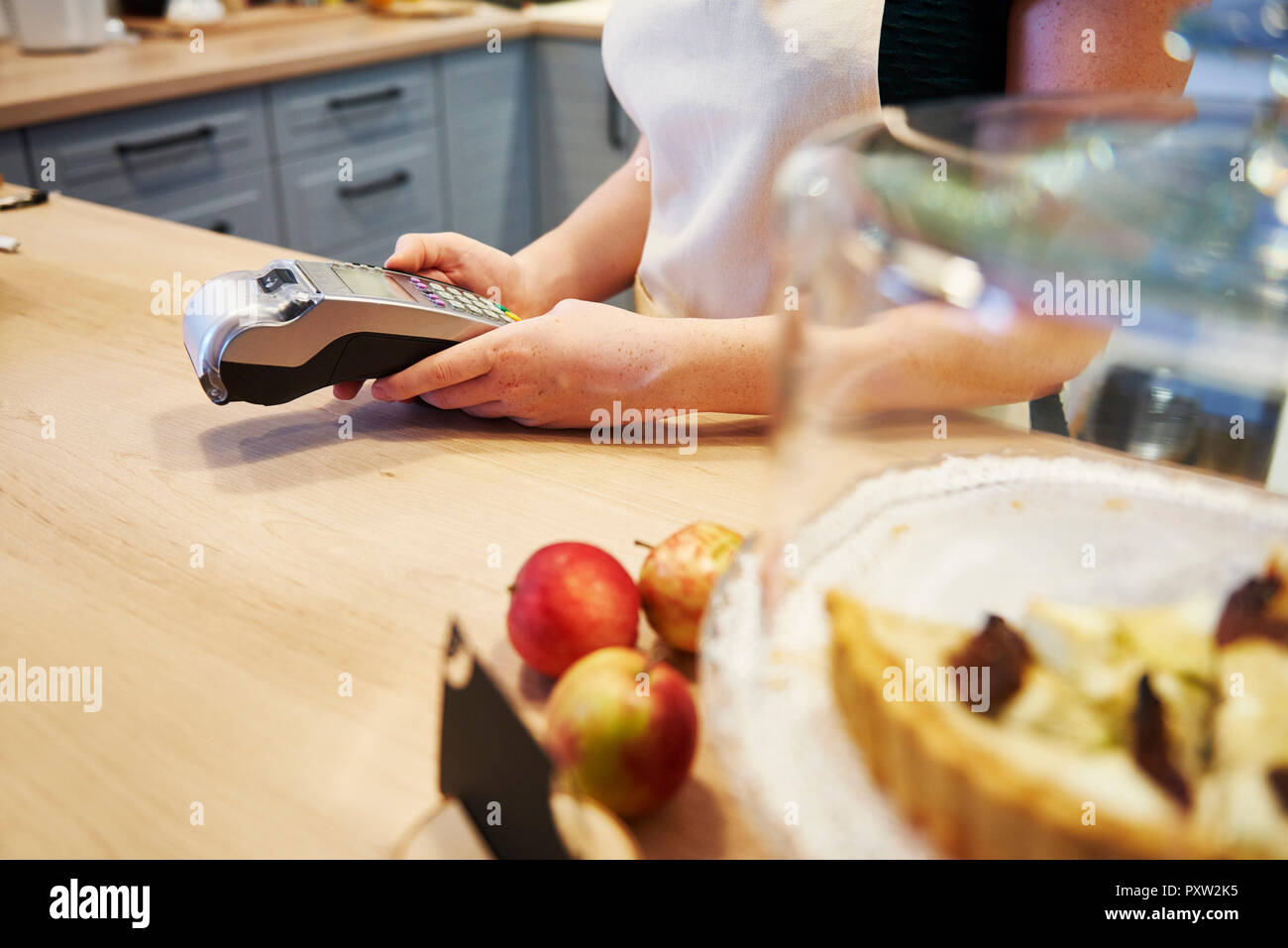 Waitress holding card reader au comptoir dans un café Banque D'Images